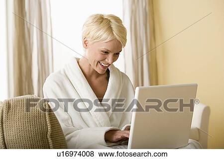 Woman using laptop at home View Large Photo Image Stock Photo - Woman using laptop at home. Fotosearch