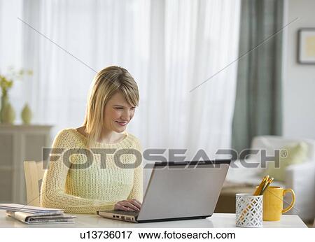 Woman working on laptop at home View Large Photo Image Stock Photo - Woman working on laptop at home. Fotosearch