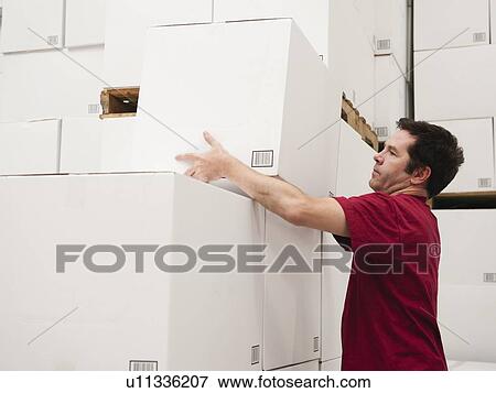 Worker stacking boxes in warehouse View Large Photo Image Stock Photo - Worker stacking boxes in warehouse. Fotosearch