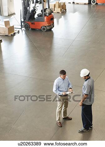 Workers talking in warehouse View Large Photo Image Stock Photo - Workers talking in warehouse. Fotosearch