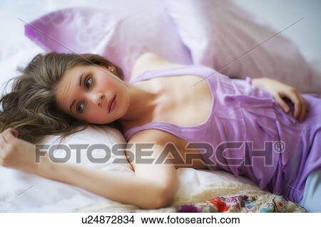 Picture - Young attractive woman lying on bed. Fotosearch
