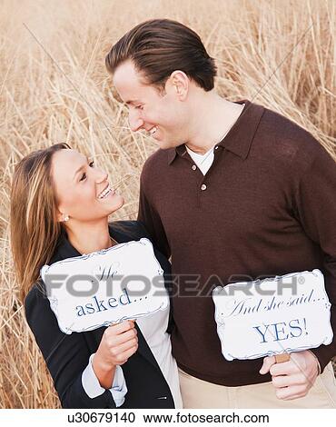 Stock Image - Young couple flirting on wheat field. Fotosearch