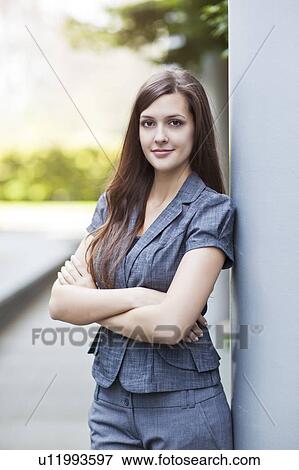 Stock Photo - Young elegant woman standing and looking at camera. Fotosearch