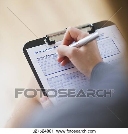 Stock Image - Young woman filling application form. Fotosearch