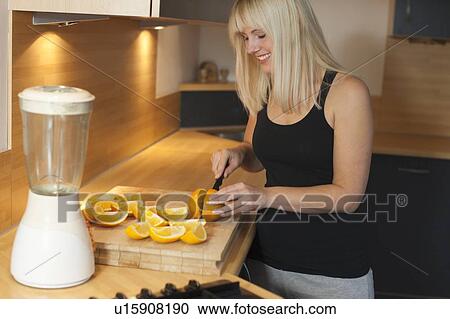 Young woman in kitchen View Large Photo Image Stock Image - Young woman in kitchen. Fotosearch