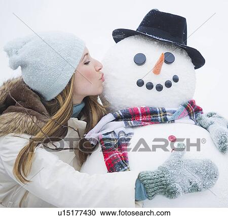 Young woman kissing snowman View Large Photo Image Stock Image - Young woman kissing snowman. Fotosearch