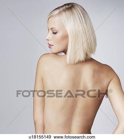Stock Photo - Young woman looking over shoulder, studio shot. Fotosearch