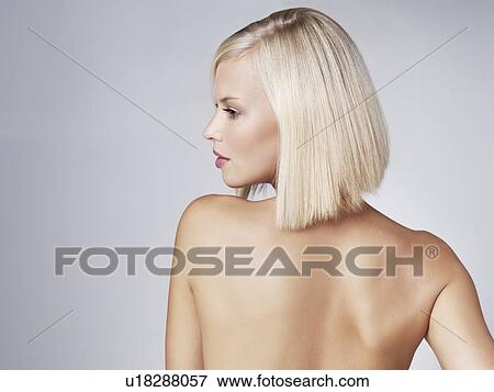 Young woman looking over shoulder, studio shot View Large Photo Image Stock Photo - Young woman looking over shoulder, studio shot. Fotosearch