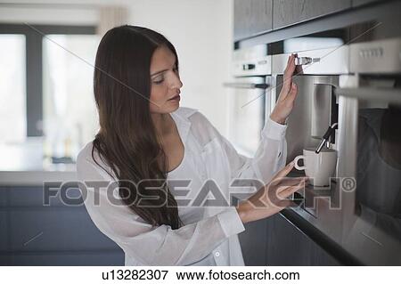 Young woman making coffee View Large Photo Image Stock Photo - Young woman making coffee. Fotosearch