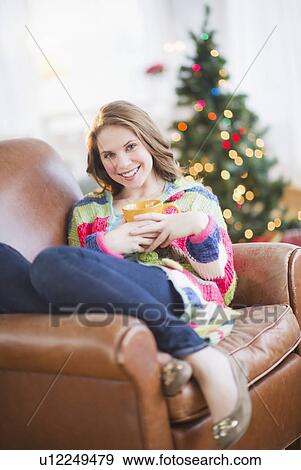 Stock Photo - Young woman relaxing on sofa. Fotosearch