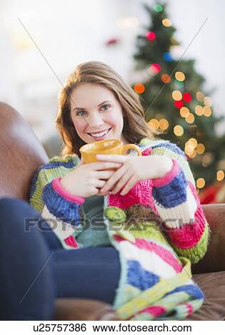 Stock Photograph - Young woman relaxing on sofa. Fotosearch