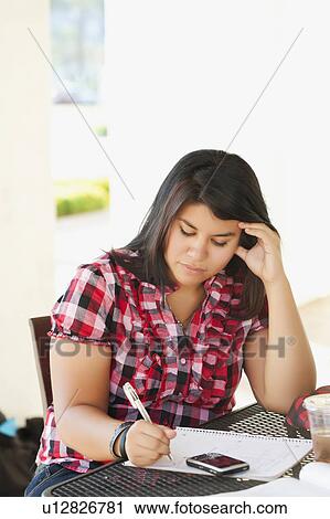 Young woman studying in outdoor cafe View Large Photo Image Stock Image - Young woman studying in outdoor cafe. Fotosearch