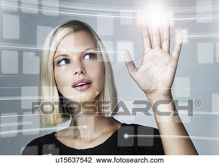 Young woman using futuristic touchscreen, studio shot View Large Photo Image Stock Image - Young woman using futuristic touchscreen, studio shot. Fotosearch