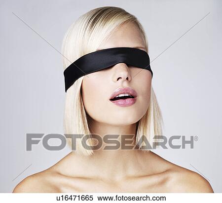 Stock Photography - Young woman wearing blindfold, studio shot. Fotosearch
