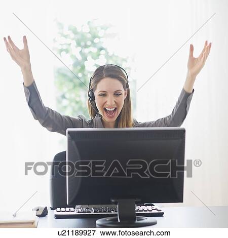 Young woman with arms raised on computer View Large Photo Image Stock Photo - Young woman with arms raised on computer. Fotosearch