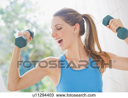 Young woman with dumbbells View Large Photo Image Stock Image - Young woman with dumbbells. Fotosearch