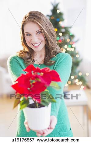 Stock Photo - Young woman with red poinsettia. Fotosearch