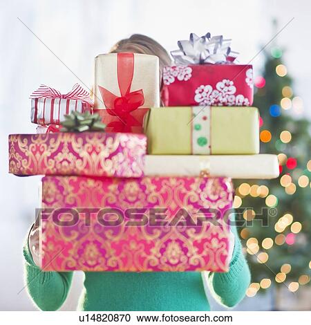 Young woman with stack of colorful Christmas gifts View Large Photo Image Stock Image - Young woman with stack of colorful Christmas gifts. Fotosearch