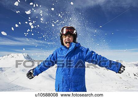 Stock Photo - Boy cheering on snowy mountaintop. Fotosearch