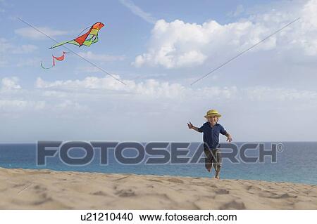 Boy flying kite on beach View Large Photo Image Stock Image - Boy flying kite on beach. Fotosearch
