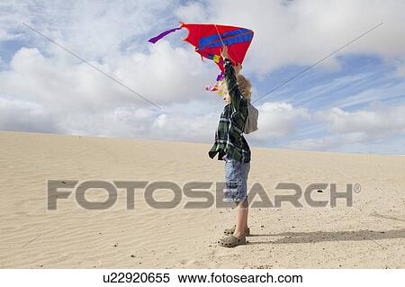 Boy flying kite on beach View Large Photo Image Stock Photography - Boy flying kite on beach. Fotosearch