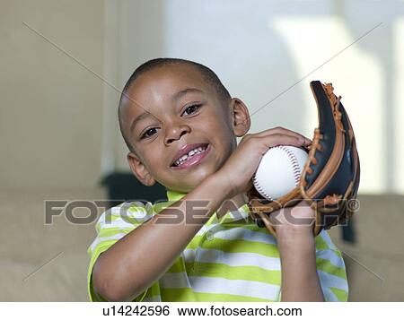 Stock Photograph - Boy holding baseball and glove. Fotosearch
