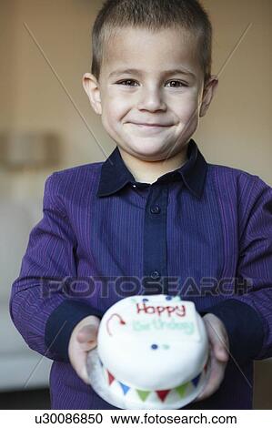 Stock Image - Boy holding miniature cake. Fotosearch