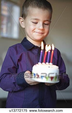 Stock Photography - Boy holding miniature cake with candles. Fotosearch