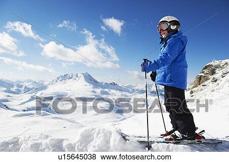 Stock Photo - Boy in skis on snowy mountaintop. Fotosearch