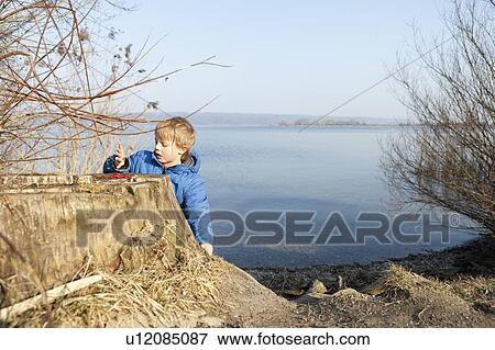 Boy playing with berries by lake View Large Photo Image Stock Photo - Boy playing with berries by lake. Fotosearch