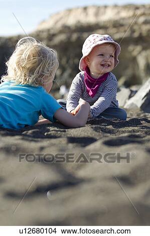 Boy playing with sibling on beach View Large Photo Image Picture - Boy playing with sibling on beach. Fotosearch