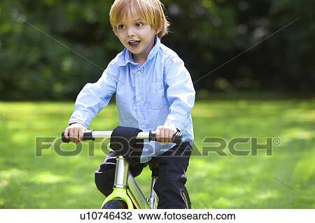 Boy riding bicycle in backyard View Large Photo Image Stock Image - Boy riding bicycle in backyard. Fotosearch