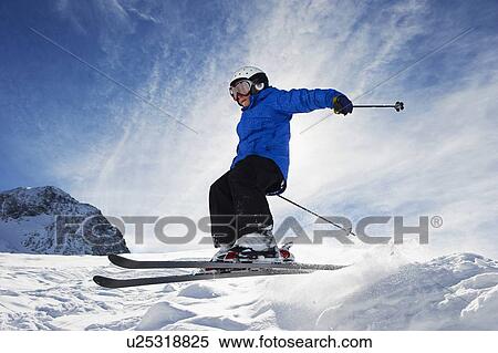 Stock Photography - Boy skiing on snowy mountainside. Fotosearch