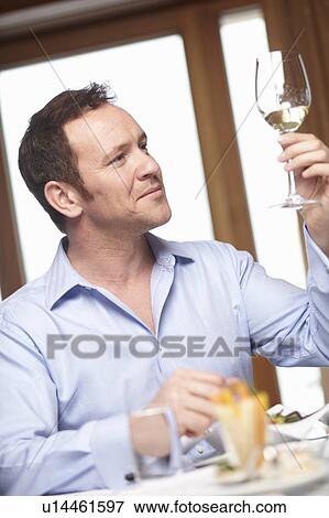 Stock Photo - Businessman examining glass of wine. Fotosearch
