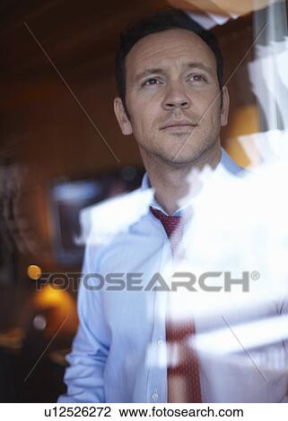 Stock Image - Businessman looking out window. Fotosearch
