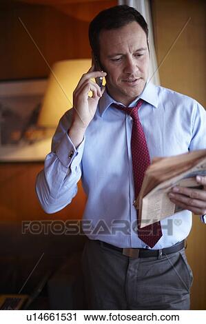 Businessman on cell phone in hotel room View Large Photo Image Stock Image - Businessman on cell phone in hotel room. Fotosearch