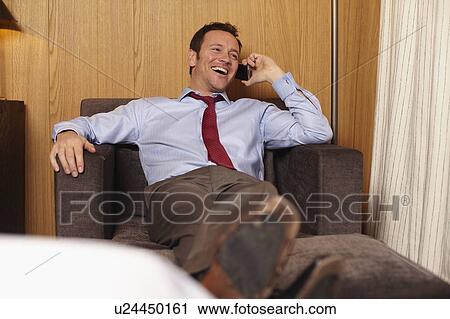 Businessman on cell phone in hotel room View Large Photo Image Stock Image - Businessman on cell phone in hotel room. Fotosearch