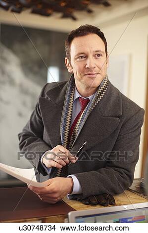 Businessman with paper at front desk View Large Photo Image Picture - Businessman with paper at front desk. Fotosearch