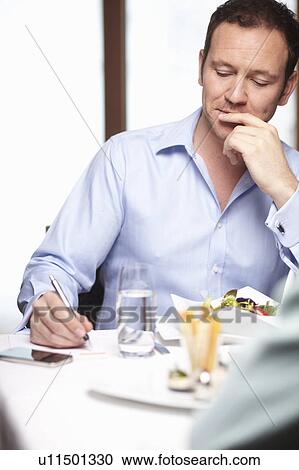 Businessman writing in cafe View Large Photo Image Stock Image - Businessman writing in cafe. Fotosearch