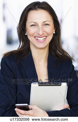Stock Photograph - Businesswoman carrying tablet computer. Fotosearch