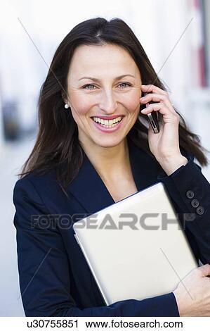 Stock Image - Businesswoman talking on cell phone. Fotosearch