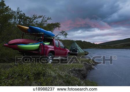 Stock Photo - Canoes on truck bed by rural river. Fotosearch