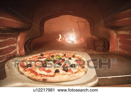 Chef pulling pizza from oven View Large Photo Image Stock Image - Chef pulling pizza from oven. Fotosearch