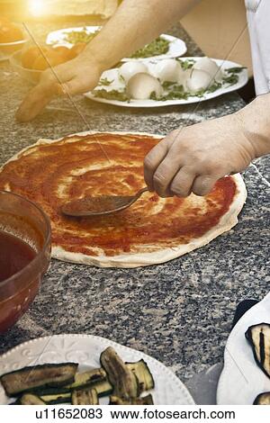 Chef spreading sauce on pizza dough View Large Photo Image Stock Image - Chef spreading sauce on pizza dough. Fotosearch