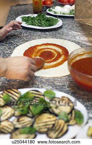 Chef spreading sauce on pizza dough View Large Photo Image Stock Image - Chef spreading sauce on pizza dough. Fotosearch