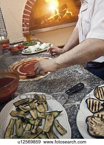 Chef spreading sauce on pizza dough View Large Photo Image Stock Photo - Chef spreading sauce on pizza dough. Fotosearch