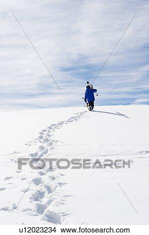 Child carrying skis up snowy mountain View Large Photo Image Picture - Child carrying skis up snowy mountain. Fotosearch