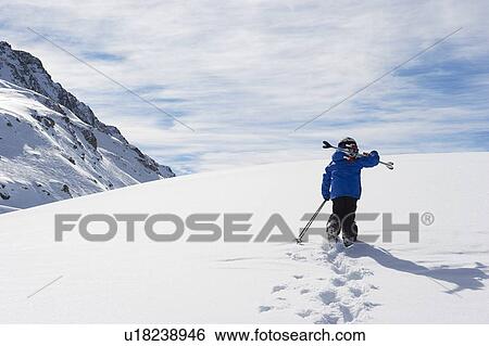 Child carrying skis up snowy mountain View Large Photo Image Stock Photograph - Child carrying skis up snowy mountain. Fotosearch