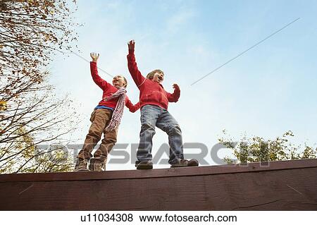 Children balancing on wooden wall View Large Photo Image Stock Photo - Children balancing on wooden wall. Fotosearch
