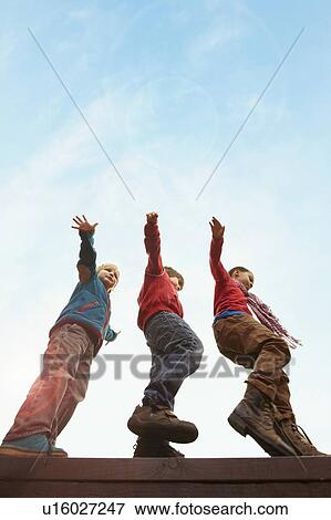 Children balancing on wooden wall View Large Photo Image Stock Photo - Children balancing on wooden wall. Fotosearch